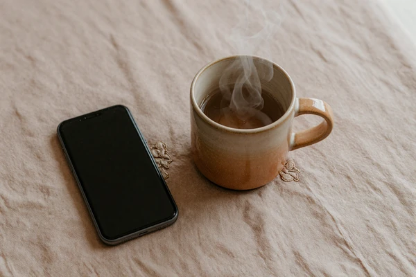 Warm mug and phone still life illustrating disclosure anxiety relief on niche dating sites